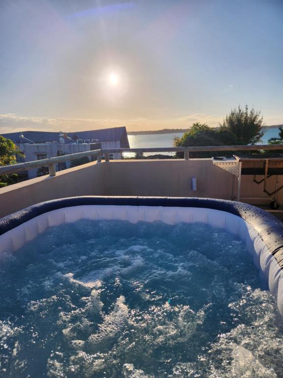 una gran piscina de agua con el sol en el fondo en Cozy pavillon with private jacuzzi on rooftop terrace - Jolly's Rock en Grand Gaube