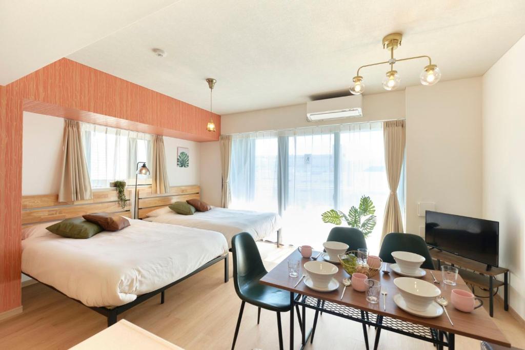 Habitación de hotel con 2 camas y mesa de comedor en Modello Sangenjaya, en Tokio