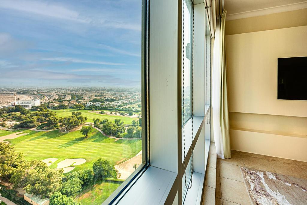 a window with a view of a golf course at Fairways Tower by Emaar, The Views and Greens in Dubai