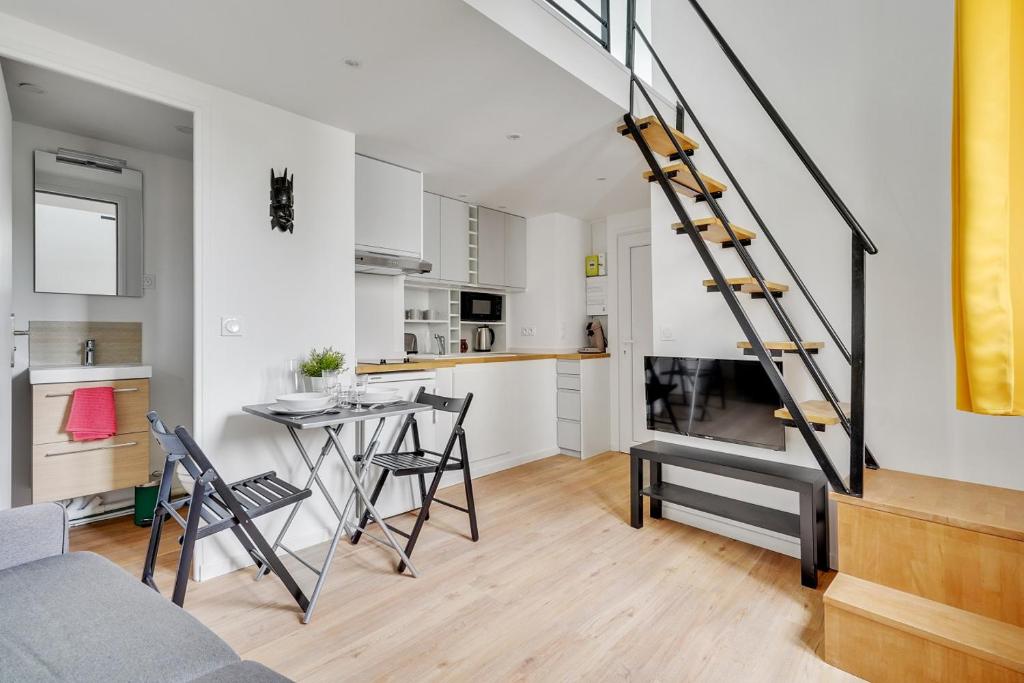 una sala de estar y una cocina con una escalera en un loft en Studio mezzanine 3-4 pers tout équipé Paris WIFI - R9 en Montreuil