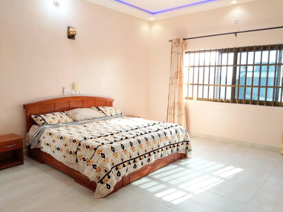 ポルト・ノボにあるPorto-Novo Charme Townhouseのベッドと大きな窓のある寝室