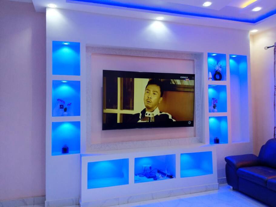 a television in a living room with blue lights at Porto-Novo Charme Townhouse in Porto-Novo