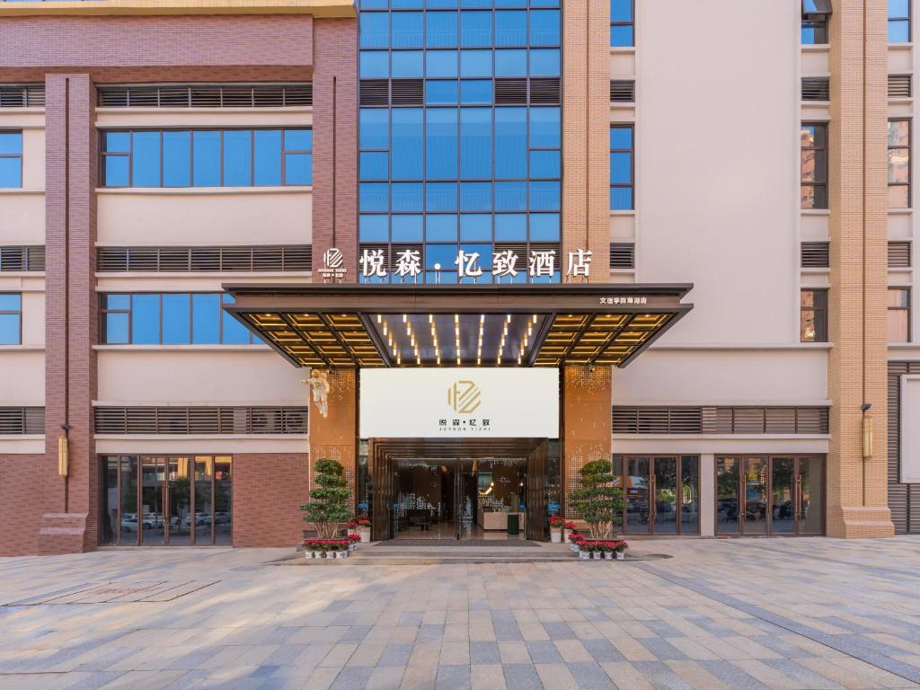 una entrada a un edificio con bancos delante en YueSen Yizhi Hotel, en Dazhou