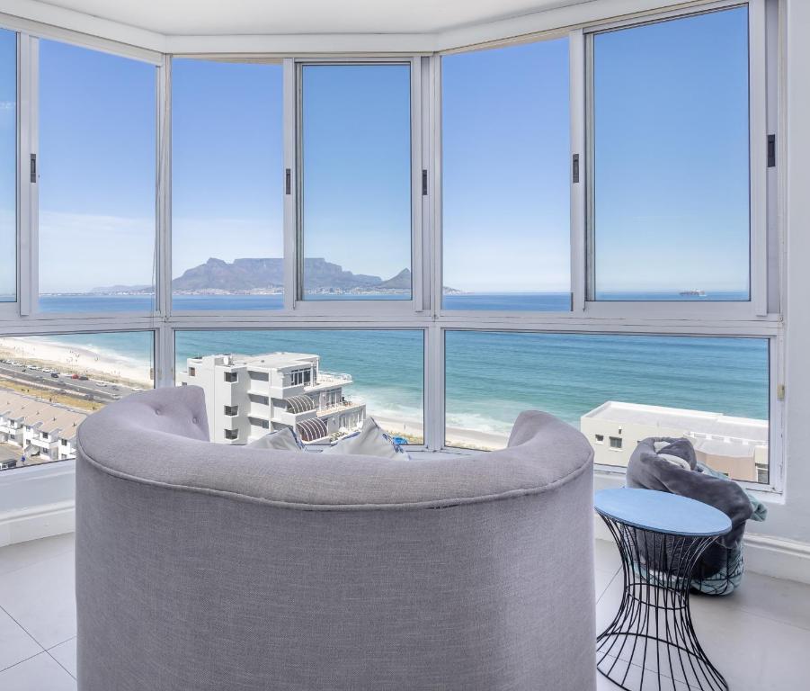 Una sala de estar con un sofá y vista al mar. en Oceanview Holiday Accommodation, en Bloubergstrand