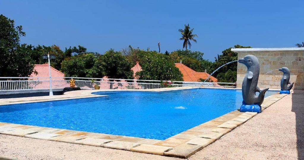 a swimming pool with two swans in the water at Grand Melka Hotel in Lovina