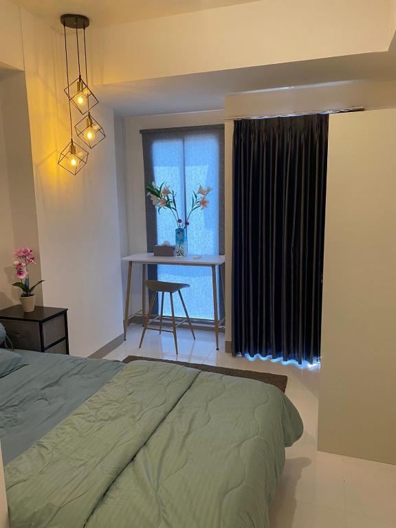 a bedroom with a bed and a window with a table at Tokyo riverside ocean view in Tangerang