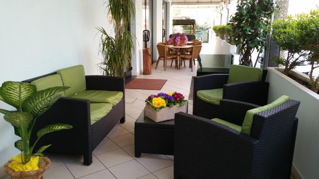 patio con sedie e tavolo con fiori di Hotel Santini a Rimini