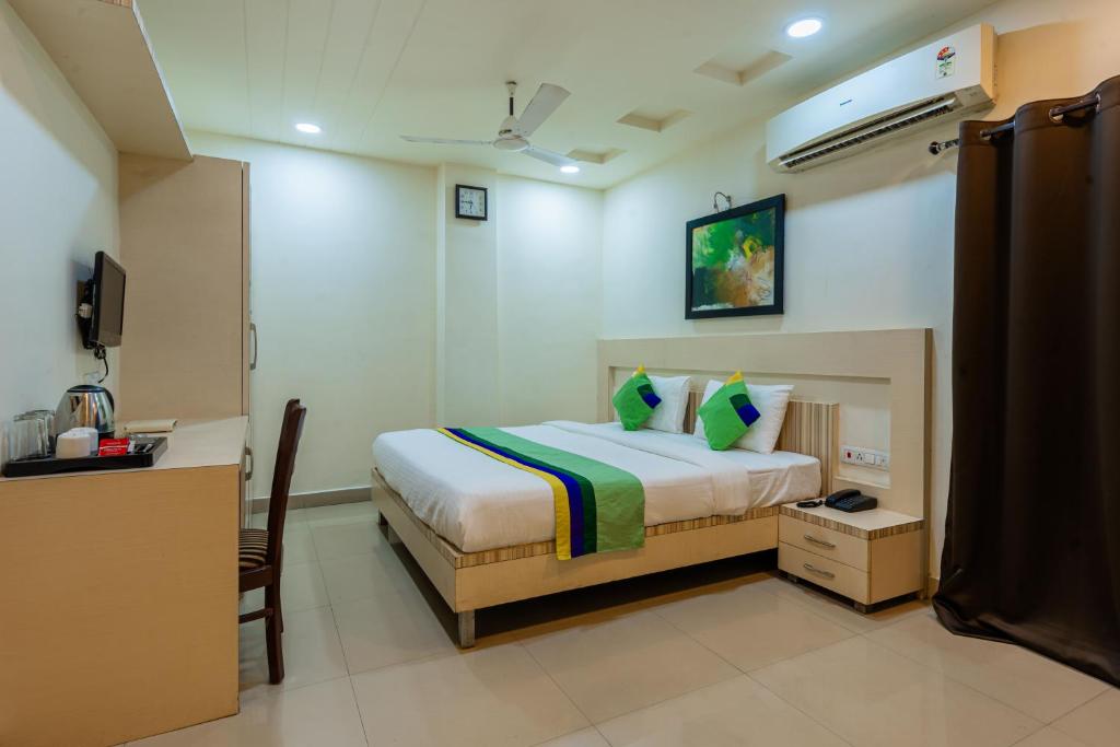 a bedroom with a bed and a desk and a television at Treebo Trend Udyam Glory in Nagpur