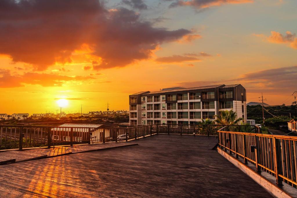 uma vista de um edifício com o pôr-do-sol ao fundo em O2Heal resort em Jeju