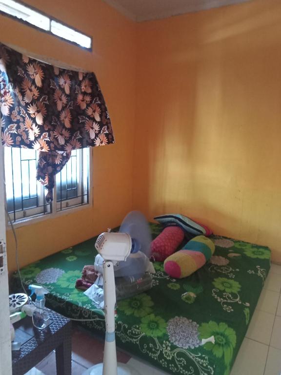 a bedroom with a bed with pillows and a lamp at Permata homestay in Karawang