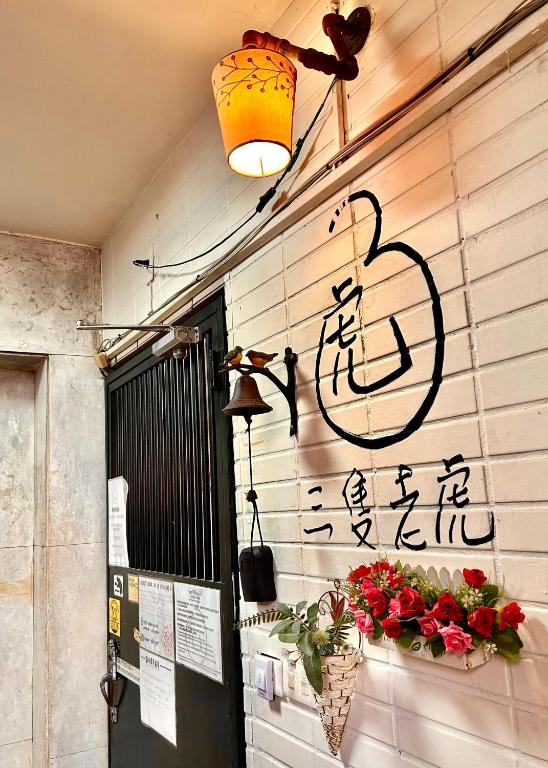 a sign on the wall of a building with flowers at Taipei Triple Tiger Inn in Taipei