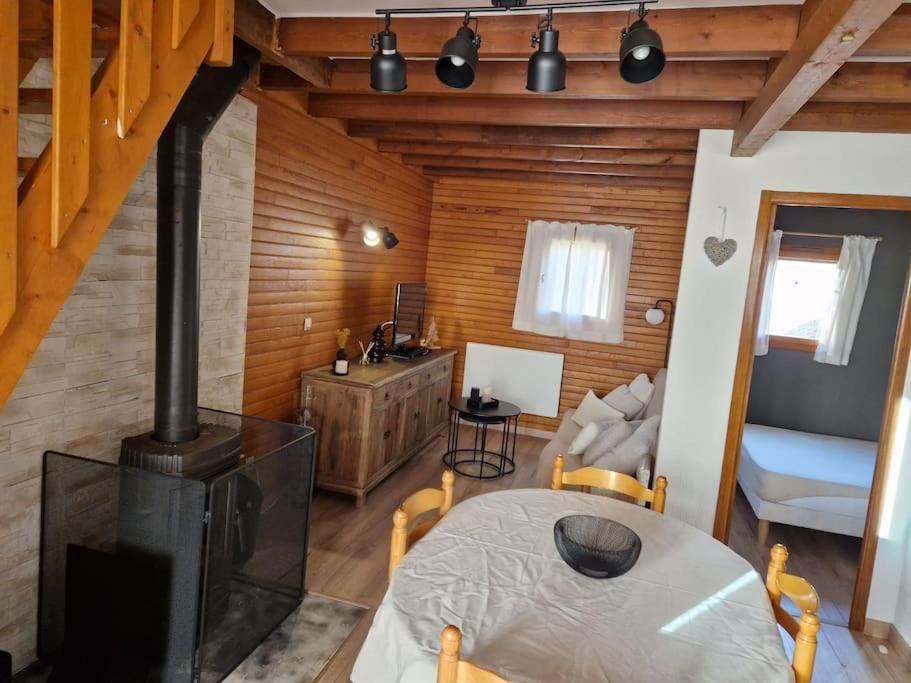 a living room with a stove and a table in a room at Petit chalet individuel à Font-romeu in Font-Romeu-Odeillo-Via