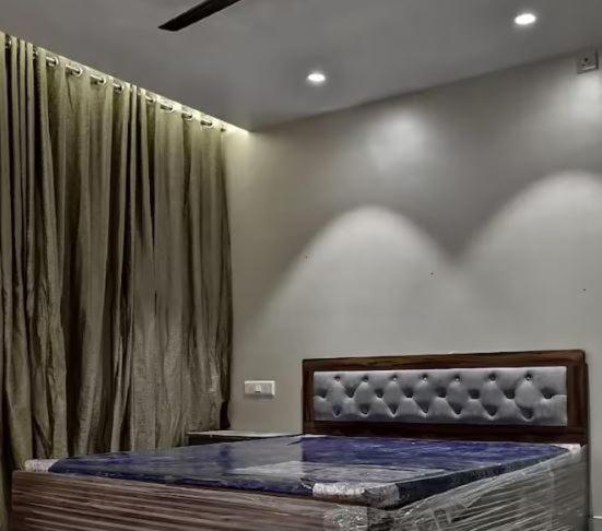 um quarto com uma cama e uma cortina em SHER 3BHK VILLA ALIBAUG em Alibaug