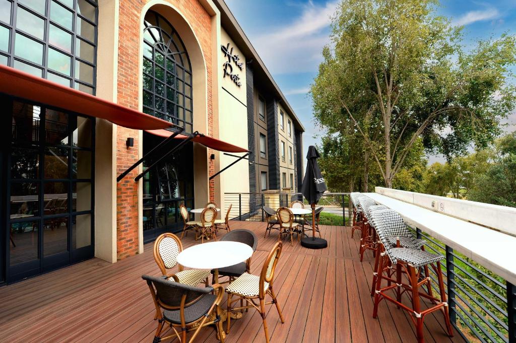 a deck with tables and chairs on a building at Hotel Perte at Montecasino in Johannesburg