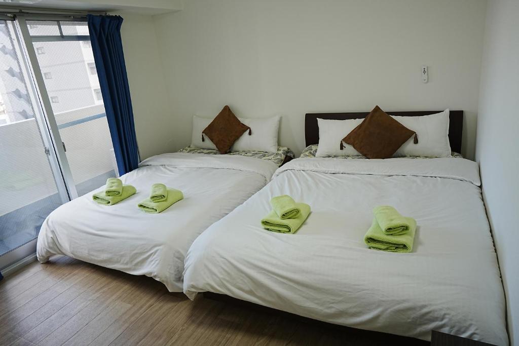 大阪市にあるOrange House 701のベッド2台(ライムグリーンのタオル付)