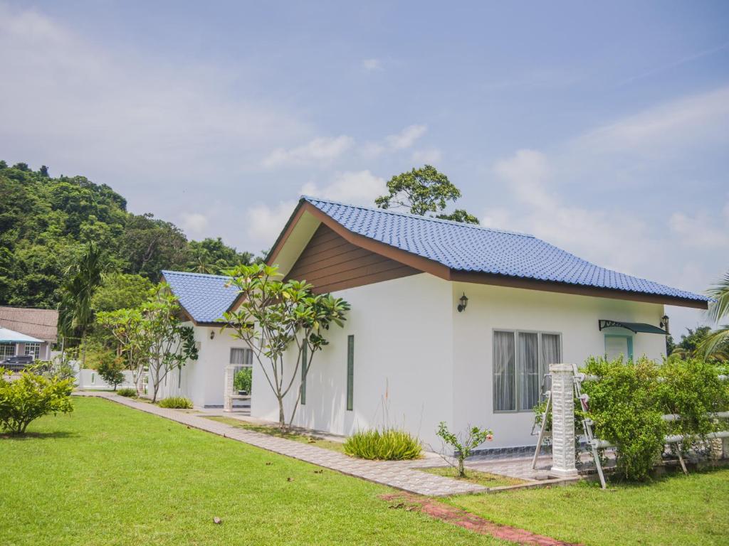 uma casa branca com um telhado azul em Halcyon Days @ Langkawi em Pantai Cenang