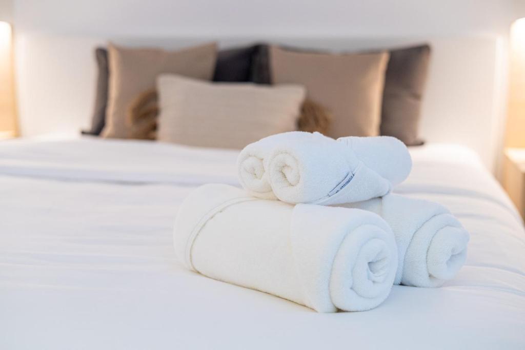 a pile of towels sitting on top of a bed at Voyage Studio In Mayan With Partial Ocean Views in Abu Dhabi