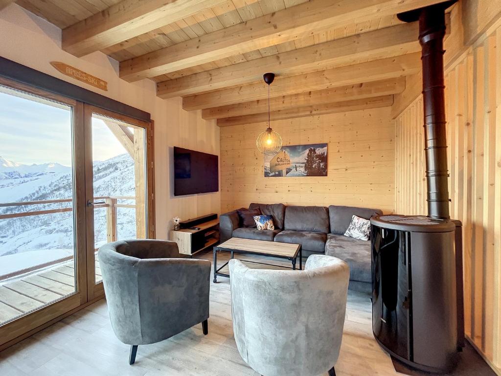 ein Wohnzimmer mit einem Sofa und einem Herd in der Unterkunft Chalet Le Vallonnet in La Toussuire