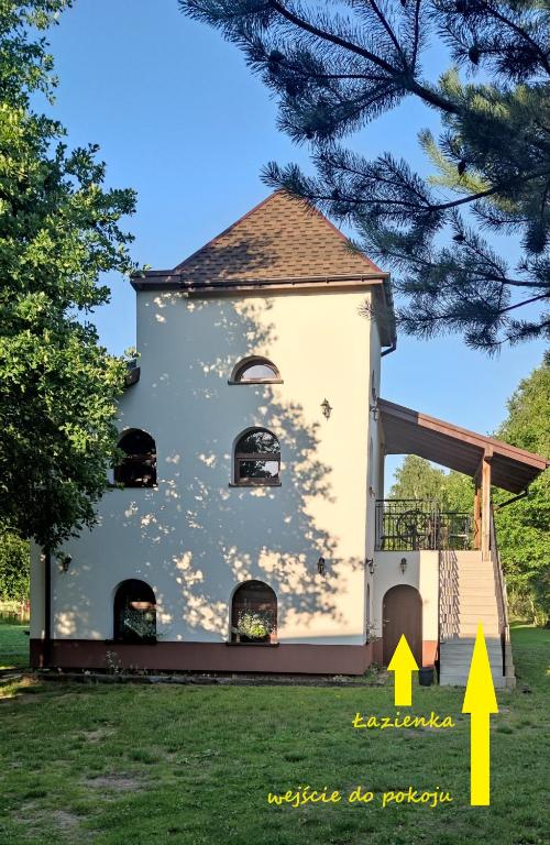 an image of a church with a yellow arrow pointing to the building at Owczarkowa Zagroda in Wąsosz
