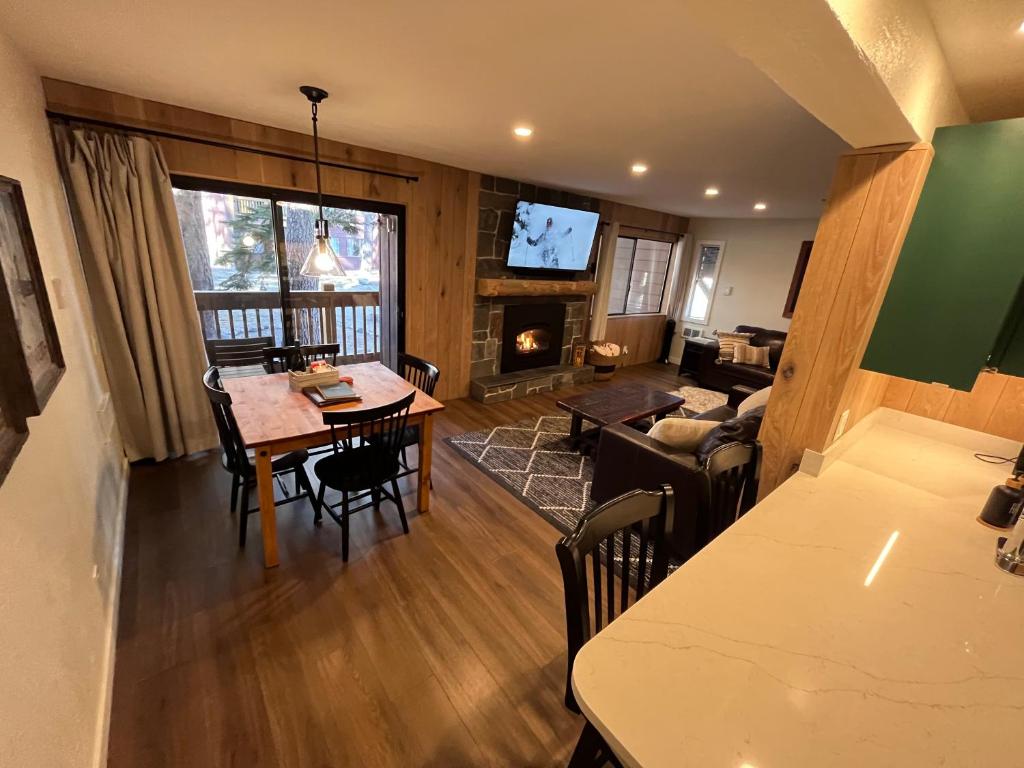 un salon avec une table et un salon avec une cheminée dans l'établissement Mammoth Ski & Racquet Club #28, New 2023 Remodel! Walk to Canyon Lodge Lifts, à Mammoth Lakes