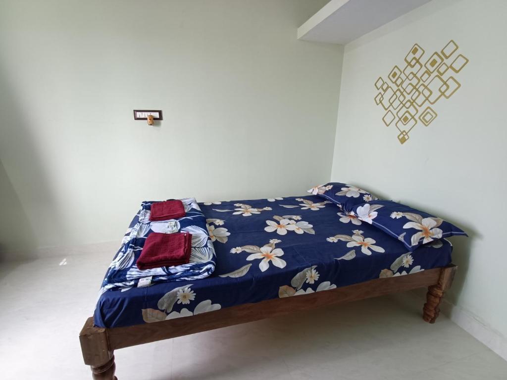 Una cama con una manta azul con flores. en Single haven 8431o31389 en Mysore