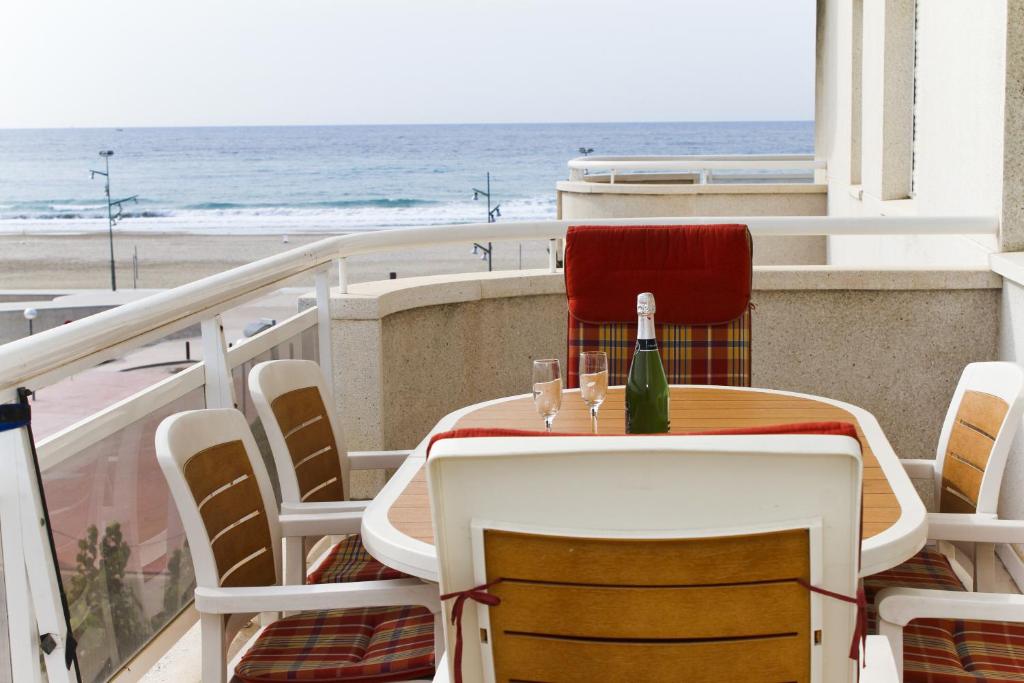 ラ・ピネーダにあるMar Pineda Planet Costa Doradaのビーチ付きのバルコニー(テーブル、椅子付)