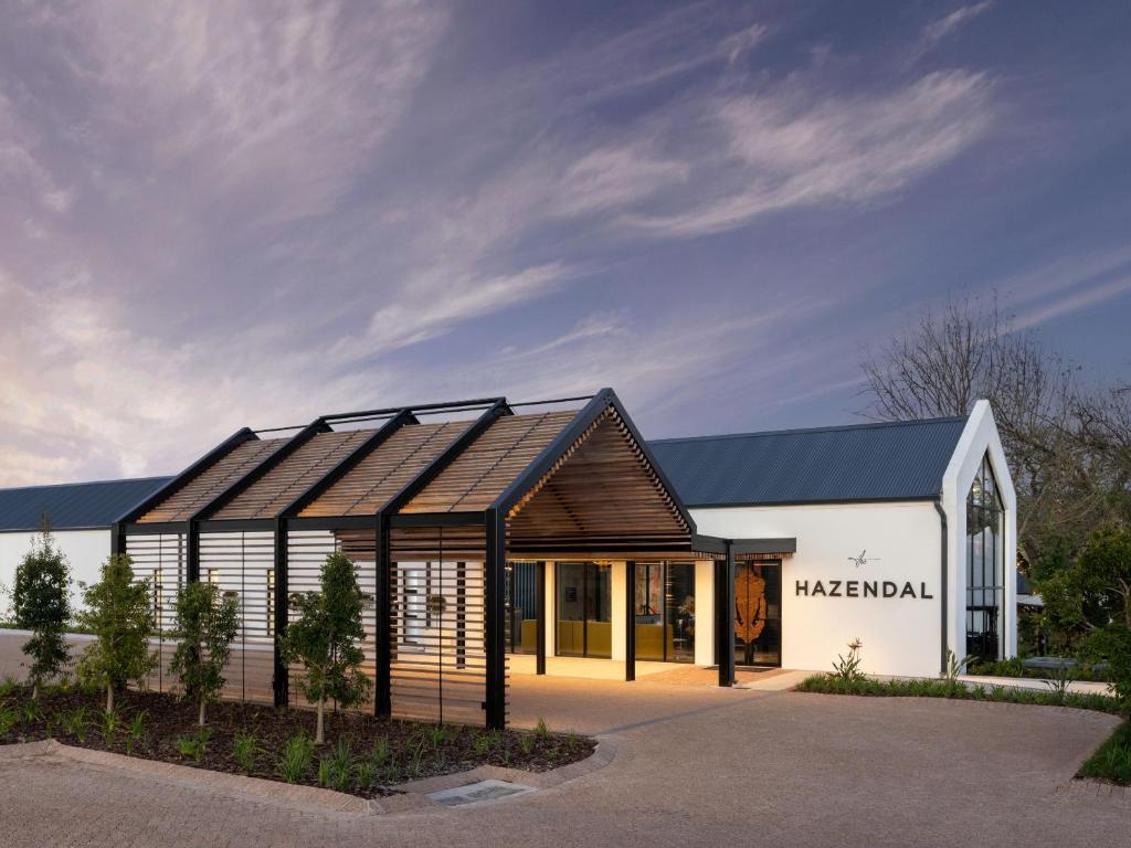 a large white building with a black roof at The Hazendal Hotel and Homestead in Stellenbosch