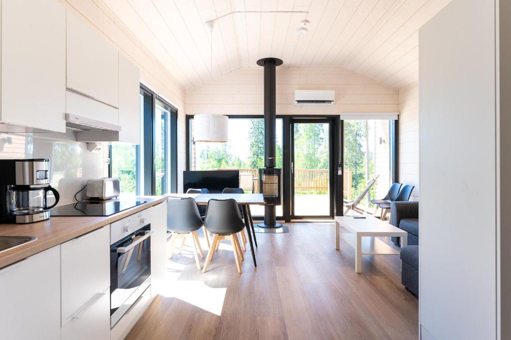 a kitchen and living room with a table and chairs at Himoskuutio 8, erillistalo, ulkoporeallas in Jämsä