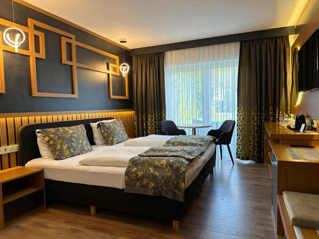 Hotel Belen Fahrenkrug في فاهْرينكروغ: غرفة فندقية بسرير كبير وطاولة