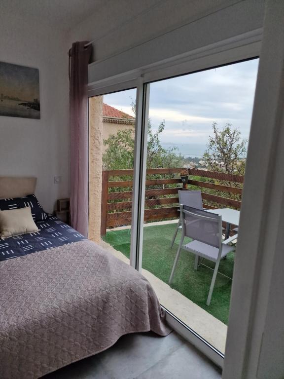Schlafzimmer mit einem Bett und einer Glasschiebetür in der Unterkunft Apt Verduron haut vue Mer "La maison du ch K" in Marseille