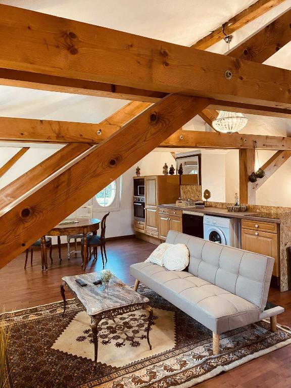 ein Wohnzimmer mit einem Sofa und einem Tisch in der Unterkunft LA MARIEFACTURE - Comme sous les toits in Saint-Avold
