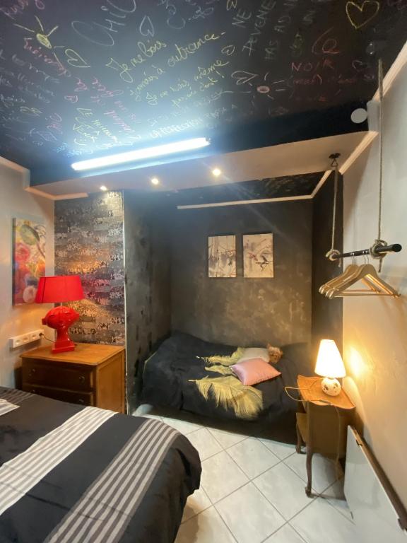 ein Schlafzimmer mit einem Bett und einer blauen Decke in der Unterkunft LA MARIEFACTURE - Comme c'est chic in Saint-Avold