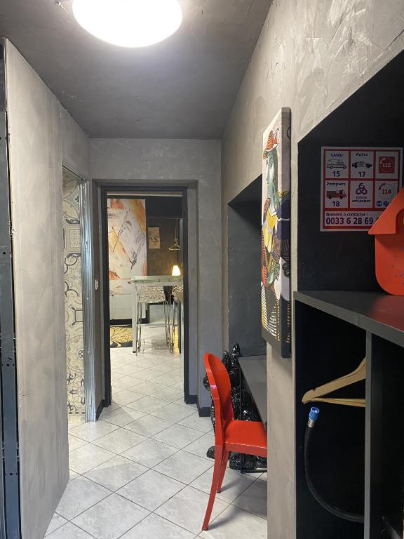 a dining room with a table and a red chair at LA MARIEFACTURE - Comme c&#39;est chic in Saint-Avold