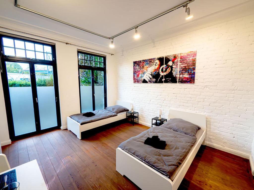 1 Schlafzimmer mit 2 Betten und Ziegelwand in der Unterkunft Work & Stay Apartment near Hamburg in Ahrensburg