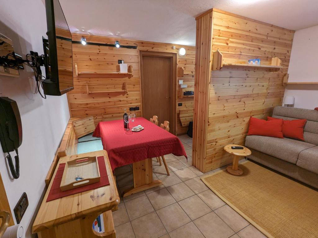 una pequeña sala de estar con mesa y sofá en Appartamento Santa Caterina, en Santa Caterina Valfurva