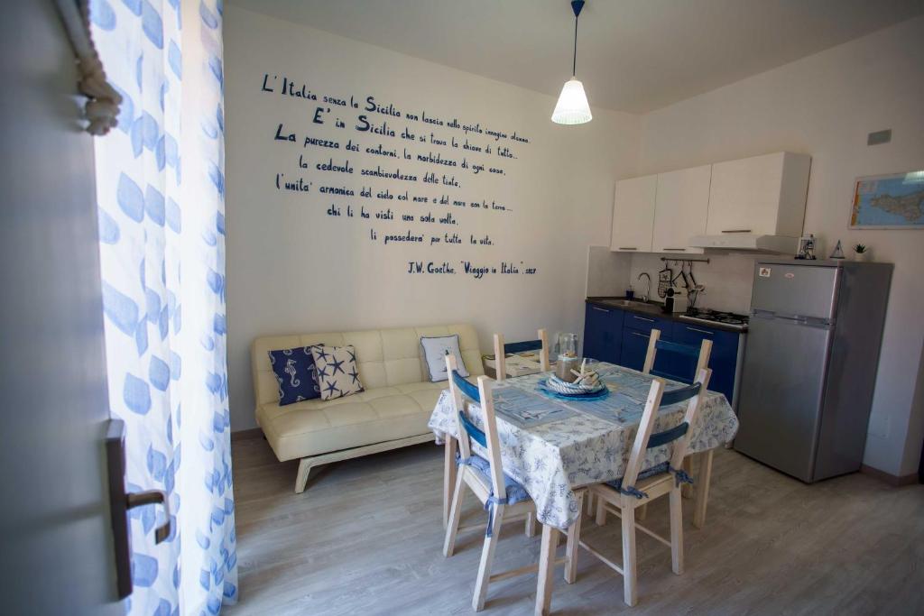 a living room with a table and a kitchen at La casa del pescatore in Oliveri