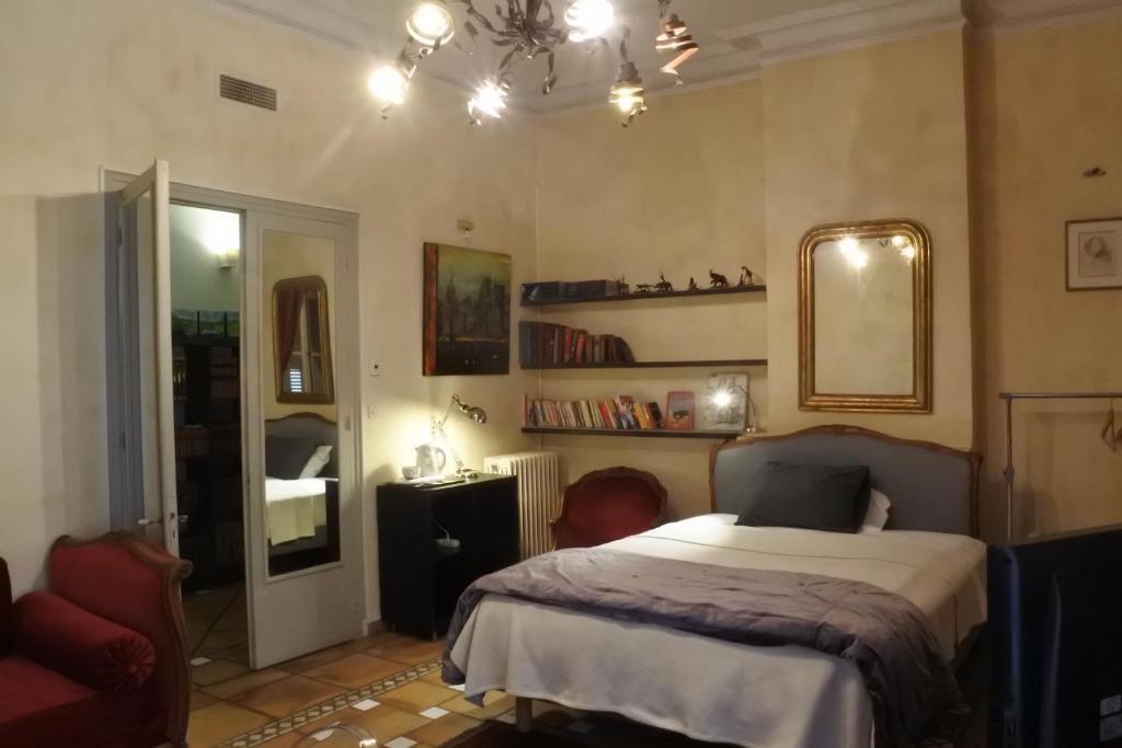 - une chambre avec un lit, un miroir et une chaise dans l'établissement Bartissol et Maillol, à Perpignan