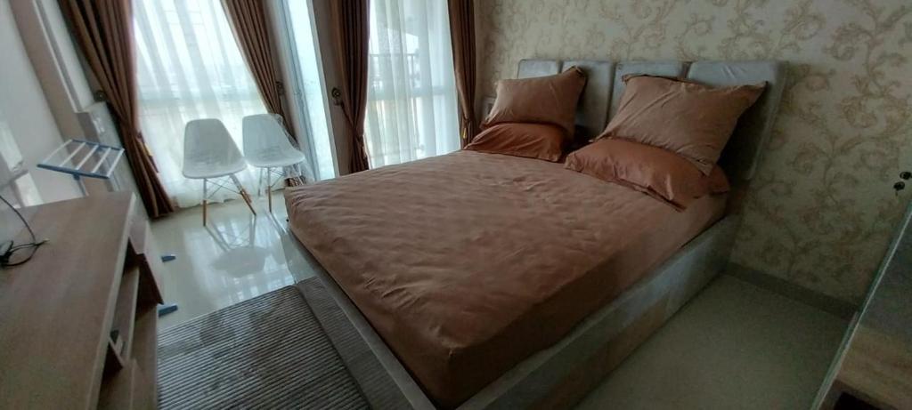 uma pequena cama num quarto com uma janela em Apartemen Skylounge Makassar em Manda
