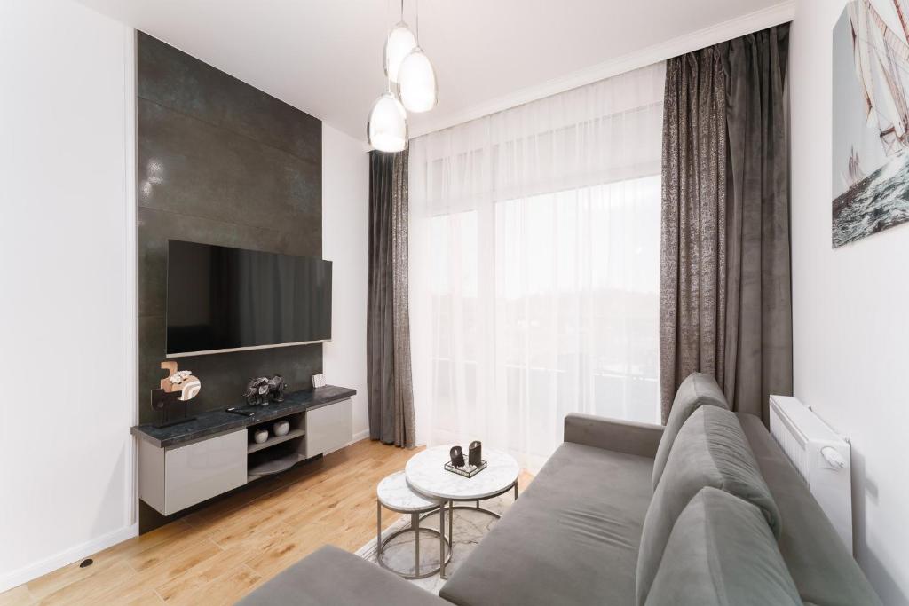 a living room with a couch and a tv at Apartament Marengo Ku Morzu by HolidaySun in Sianozety