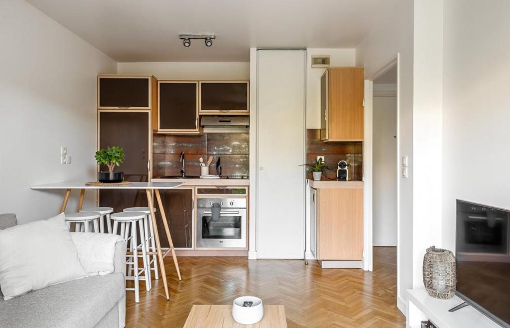 a kitchen and living room with a couch and a table at Appartement Hermitage à 10 minutes de Disney in Montévrain
