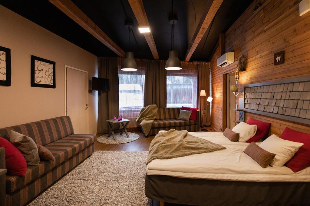 a living room with a bed and a couch at Santa's Hotel Aurora & Igloos in Luosto