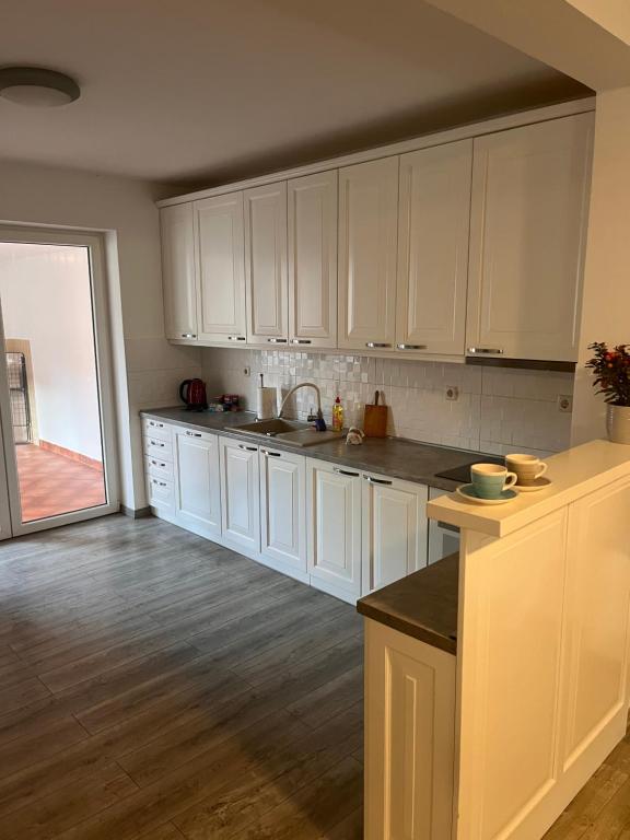 a kitchen with white cabinets and a counter top at Kuća za odmor “Viola” in Vukovar