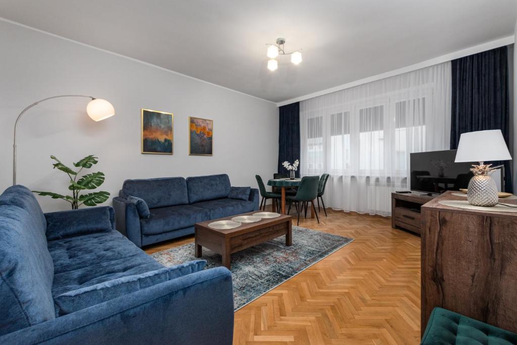 sala de estar con sofás azules y TV en Lewicka 8 by Homeprime en Varsovia