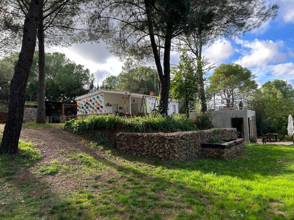 a camper in a park with trees and grass at Stone Garden, Casa en plena naturaleza in Uceda