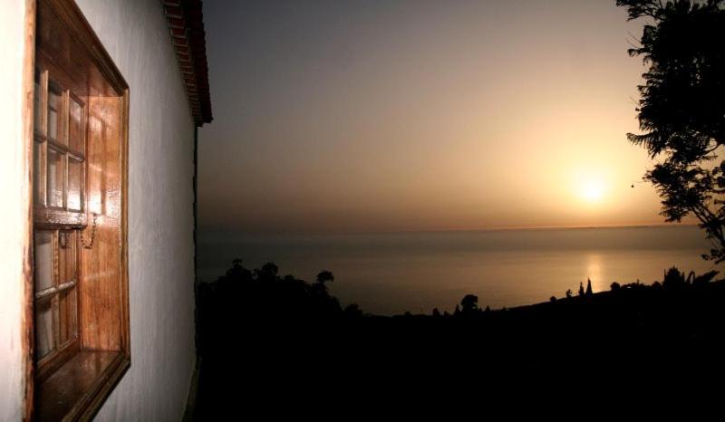 a view of the sunset from a window of a house at Casa Sabela con vistas al MAR in Arecida
