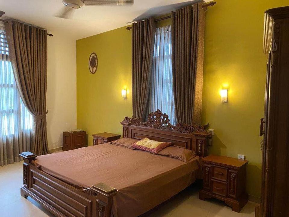 a bedroom with a large bed and two windows at Luxury Apartment in Kaduwela