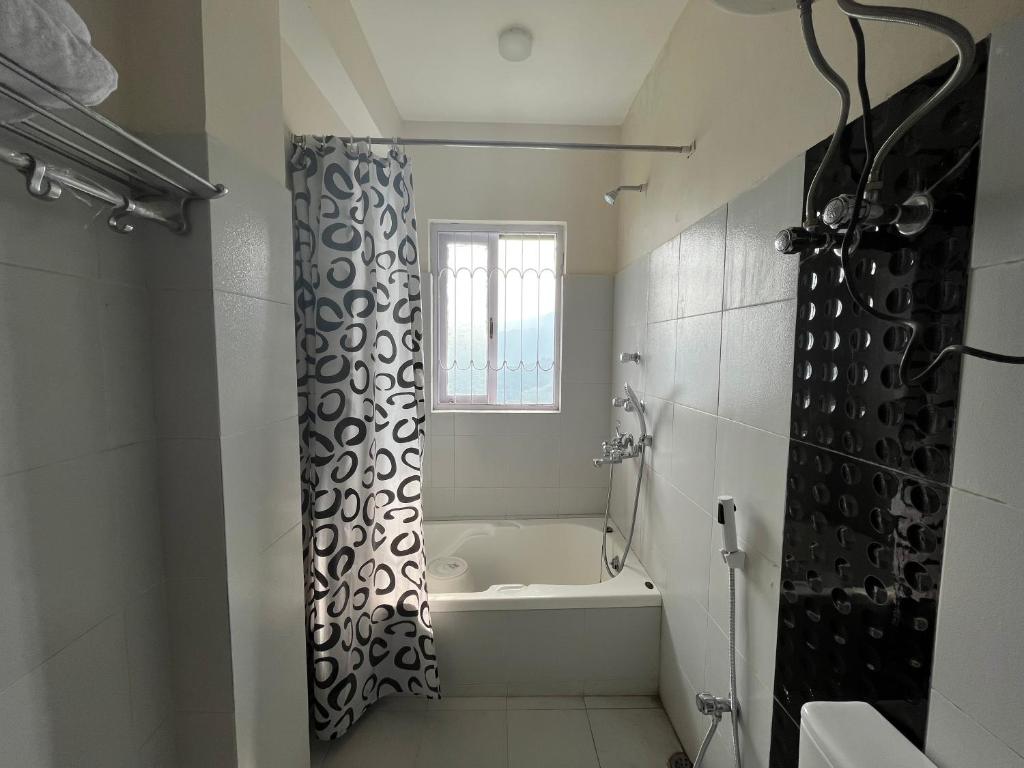 Bahar Retreat And Spa , Gangtok في جانجتوك: حمام مع حوض استحمام وستارة دش