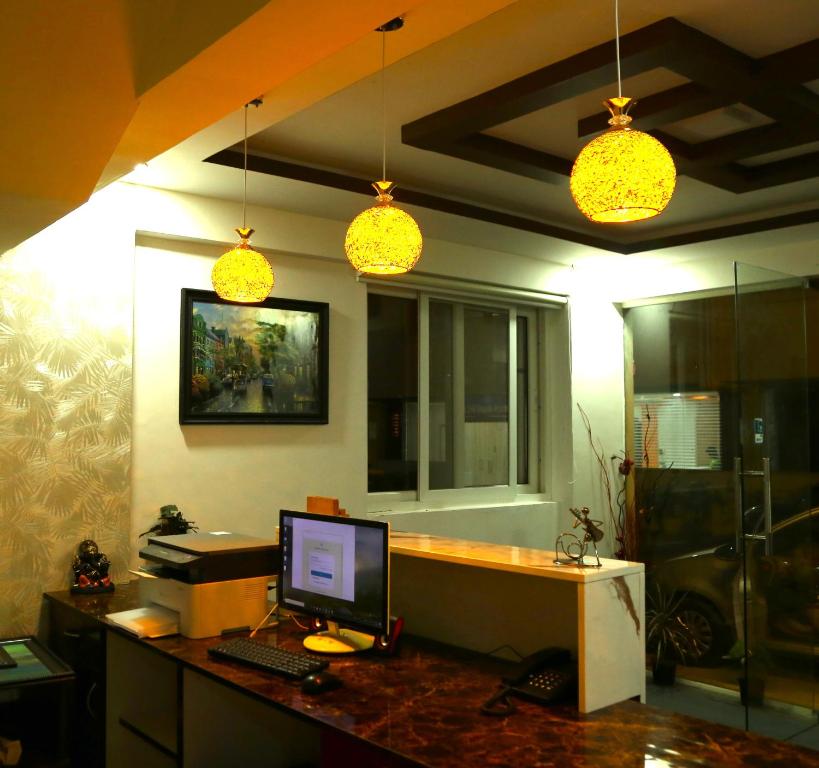 an office with a computer on a desk with lights at Hotel Bangalore Airport inn, Airport Pickup & Drop Available 24X7 in Yelahanka
