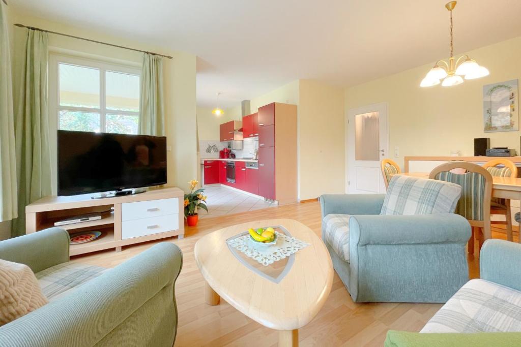 a living room with a couch and a tv and a table at Jägerstrasse 7 Ferienwohnung 8 in Kölpinsee