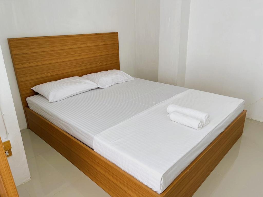 ein Bett mit weißer Bettwäsche und zwei Handtüchern darauf in der Unterkunft Palace Hostel พาเลส โฮสเทล in Amphoe Phra Khanong
